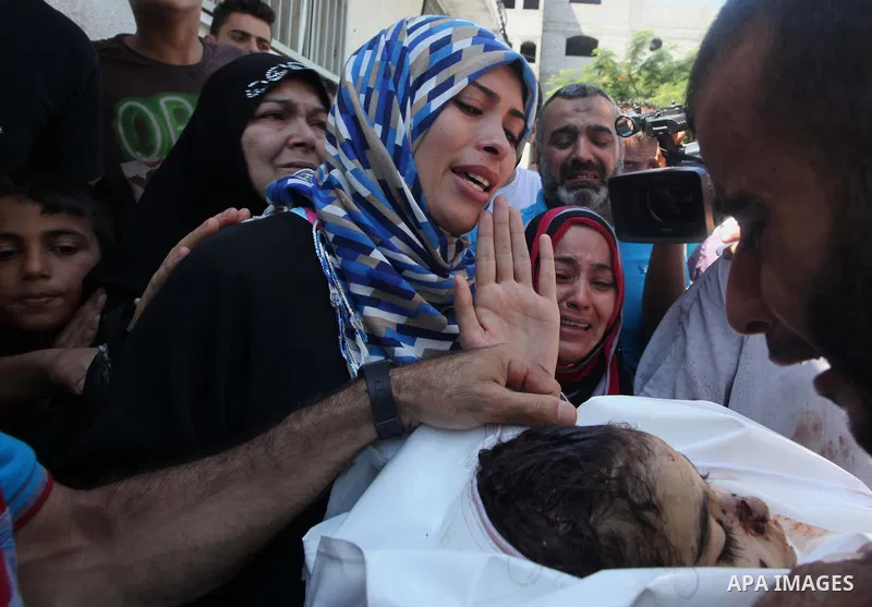 The mother (2L) and aunt (C) of Palestinian girl, Layan al-Silk, mourn during her funeral in Gaza City on July 31, 2014. At least 10 people were killed in Israeli strikes on central and southern Gaza bringing the Palesti...