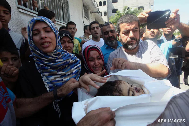The mother (2L) and aunt (C) of Palestinian girl, Layan al-Silk, mourn during her funeral in Gaza City on July 31, 2014. At least 10 people were killed in Israeli strikes on central and southern Gaza bringing the Palesti...