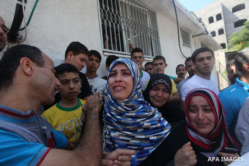The mother (2L) and aunt (C) of Palestinian girl, Layan al-Silk, mourn during her funeral in Gaza City on July 31, 2014. At least 10 people were killed in Israeli strikes on central and southern Gaza bringing the Palesti...