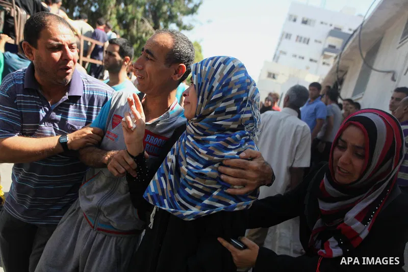 Palestinian relatives of Mahmud Rajab mourn outside the morgue of al-Shifa hospital in Gaza City on July 31, 2014. At least 10 people were killed in Israeli strikes on central and southern Gaza bringing the Palestinian d...