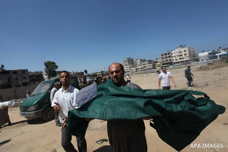 A Palestinian man carries the body of Palestinian girl, Layan al-Silk at a cemetery in Gaza City July 31, 2014. Israel did not comment immediately on an incident on Wednesday, in nearby Shejaia, in which Palestinian offi...