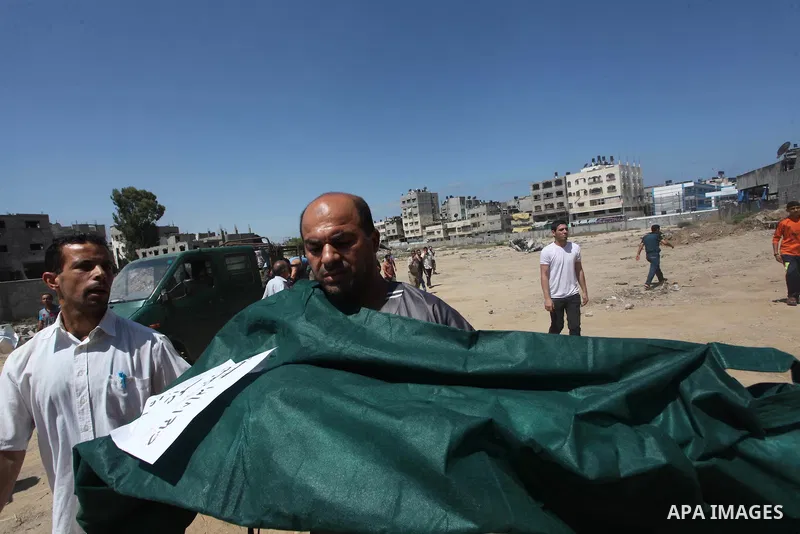 A Palestinian man carries the body of Palestinian girl, Layan al-Silk at a cemetery in Gaza City July 31, 2014. Israel did not comment immediately on an incident on Wednesday, in nearby Shejaia, in which Palestinian offi...