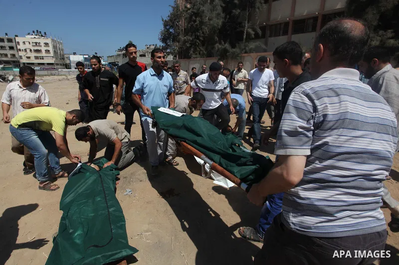 Palestinian men bury next to the bodies of Palestinians from the al-Silk family, whom medics said were killed by Israeli shelling near a market in Shejaia at a cemetery in Gaza City July 31, 2014. Israel did not comment...
