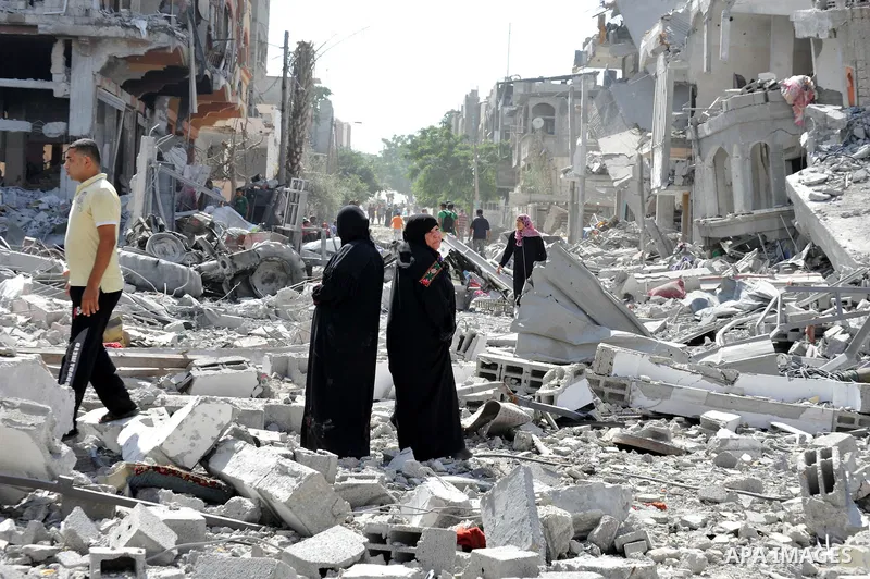 Palestinians carry their belongings from their destroyed houses in Beit Hanoun, Gaza Strip, August 1, 2014. A Gaza ceasefire was in jeopardy just hours after it began on Friday, with the Islamist group Hamas saying Israe...