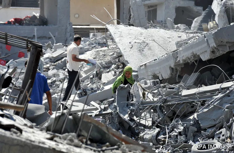 Palestinians carry their belongings from their destroyed houses in Beit Hanoun, Gaza Strip, August 1, 2014. A Gaza ceasefire was in jeopardy just hours after it began on Friday, with the Islamist group Hamas saying Israe...