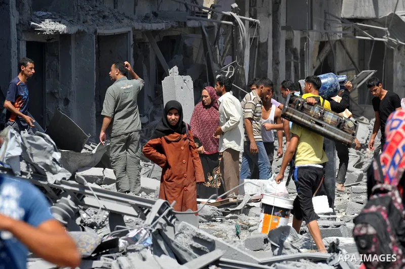 Palestinians carry their belongings from their destroyed houses in Beit Hanoun, Gaza Strip, August 1, 2014. A Gaza ceasefire was in jeopardy just hours after it began on Friday, with the Islamist group Hamas saying Israe...