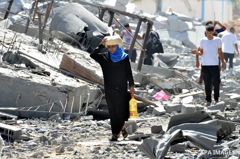Palestinians carry their belongings from their destroyed houses in Beit Hanoun, Gaza Strip, August 1, 2014. A Gaza ceasefire was in jeopardy just hours after it began on Friday, with the Islamist group Hamas saying Israe...
