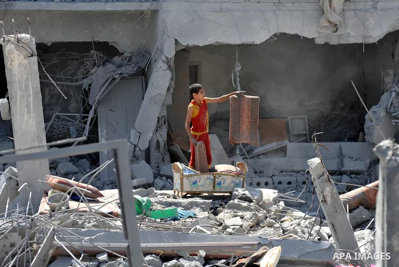 Palestinians carry their belongings from their destroyed houses in Beit Hanoun, Gaza Strip, August 1, 2014. A Gaza ceasefire was in jeopardy just hours after it began on Friday, with the Islamist group Hamas saying Israe...