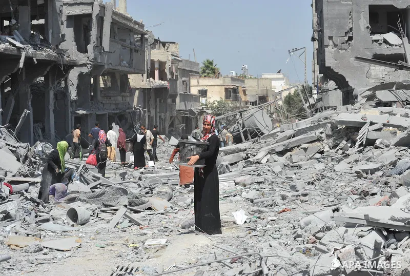 Palestinians carry their belongings from their destroyed houses in Beit Hanoun, Gaza Strip, August 1, 2014. A Gaza ceasefire was in jeopardy just hours after it began on Friday, with the Islamist group Hamas saying Israe...