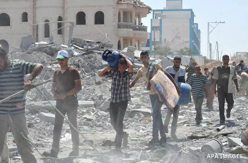 Palestinians carry their belongings from their destroyed houses in Beit Hanoun, Gaza Strip, August 1, 2014. A Gaza ceasefire was in jeopardy just hours after it began on Friday, with the Islamist group Hamas saying Israe...