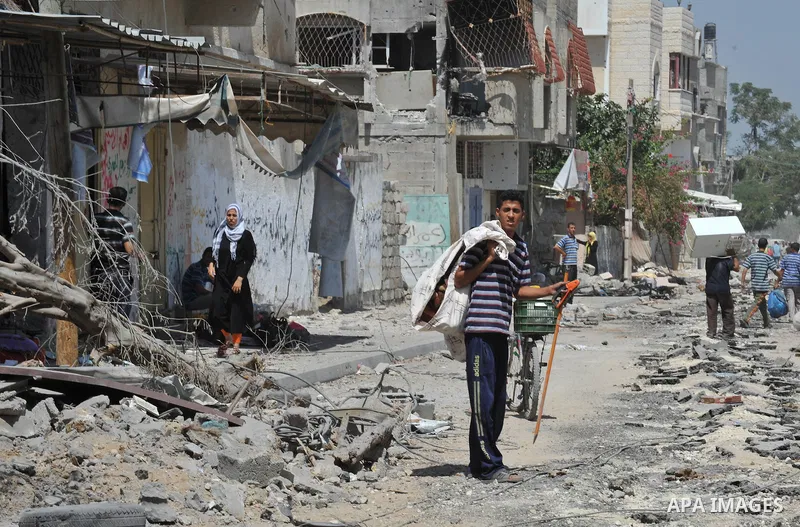 Palestinians carry their belongings from their destroyed houses in Beit Hanoun, Gaza Strip, August 1, 2014. A Gaza ceasefire was in jeopardy just hours after it began on Friday, with the Islamist group Hamas saying Israe...