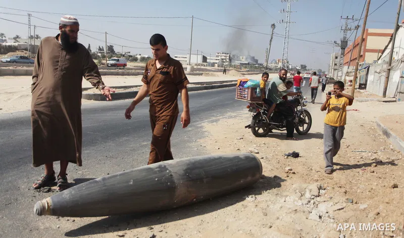 Palestinians look at an unexploded Israeli missile, which witnesses said was fired by an Israeli aircraft on a street in Deir El-Balah in the central Gaza Strip August 1, 2014. A Gaza ceasefire crumbled only hours after...