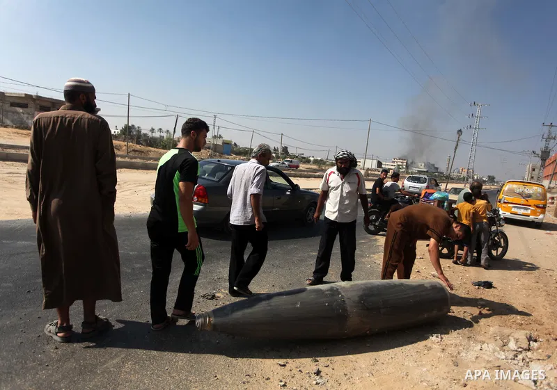 Palestinians look at an unexploded Israeli missile, which witnesses said was fired by an Israeli aircraft on a street in Deir El-Balah in the central Gaza Strip August 1, 2014. A Gaza ceasefire crumbled only hours after...