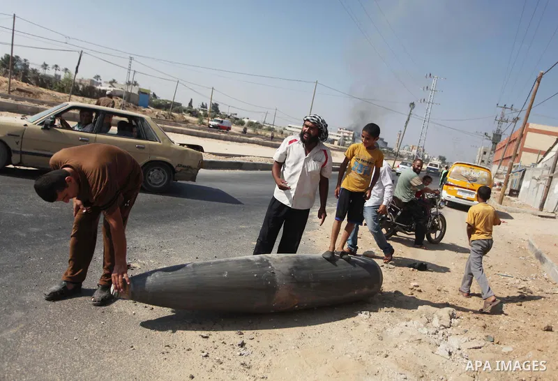 Palestinians look at an unexploded Israeli missile, which witnesses said was fired by an Israeli aircraft on a street in Deir El-Balah in the central Gaza Strip August 1, 2014. A Gaza ceasefire crumbled only hours after...