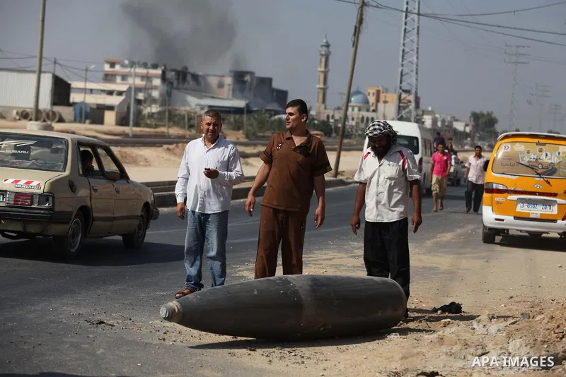 Palestinians look at an unexploded Israeli missile, which witnesses said was fired by an Israeli aircraft on a street in Deir El-Balah in the central Gaza Strip August 1, 2014. A Gaza ceasefire crumbled only hours after...