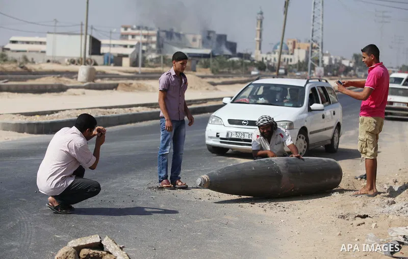 Palestinians look at an unexploded Israeli missile, which witnesses said was fired by an Israeli aircraft on a street in Deir El-Balah in the central Gaza Strip August 1, 2014. A Gaza ceasefire crumbled only hours after...
