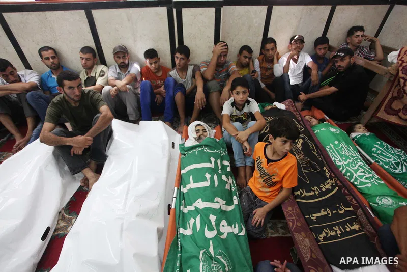 Palestinian relatives mourn for eight members of the Bayoumi family, who were killed in an Israeli air strike on their building, at Al Qassam mosque during their funeral in Nusseirat refugee camp, in the central Gaza Str...