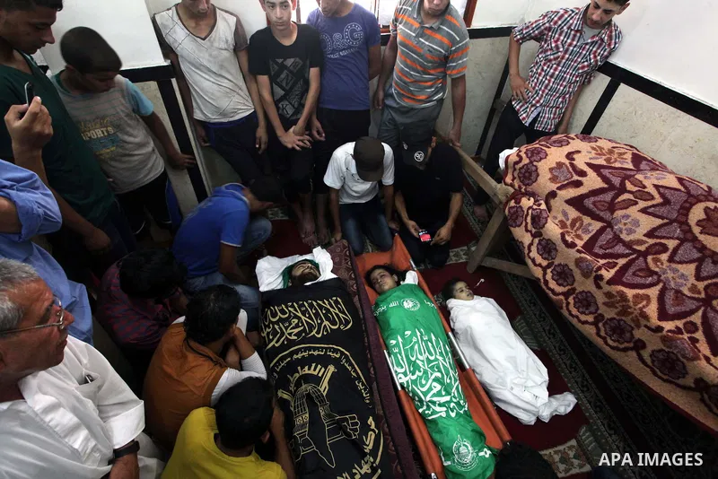Palestinian relatives mourn for eight members of the Bayoumi family, who were killed in an Israeli air strike on their building, at Al Qassam mosque during their funeral in Nusseirat refugee camp, in the central Gaza Str...