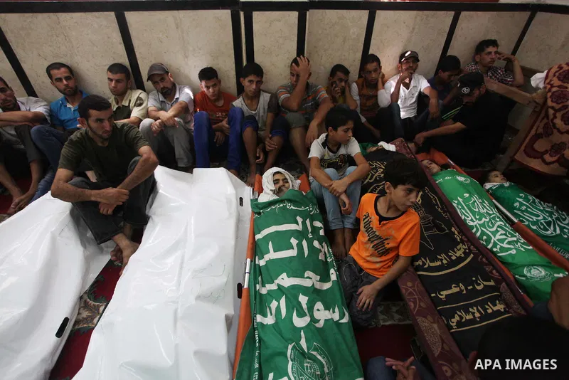 Palestinian relatives mourn for eight members of the Bayoumi family, who were killed in an Israeli air strike on their building, at Al Qassam mosque during their funeral in Nusseirat refugee camp, in the central Gaza Str...