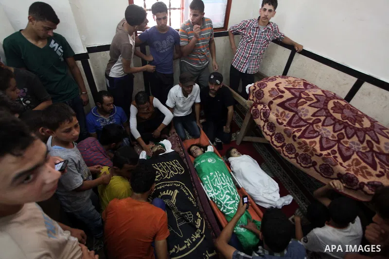 Palestinian relatives mourn for eight members of the Bayoumi family, who were killed in an Israeli air strike on their building, at Al Qassam mosque during their funeral in Nusseirat refugee camp, in the central Gaza Str...