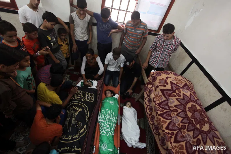 Palestinian relatives mourn for eight members of the Bayoumi family, who were killed in an Israeli air strike on their building, at Al Qassam mosque during their funeral in Nusseirat refugee camp, in the central Gaza Str...