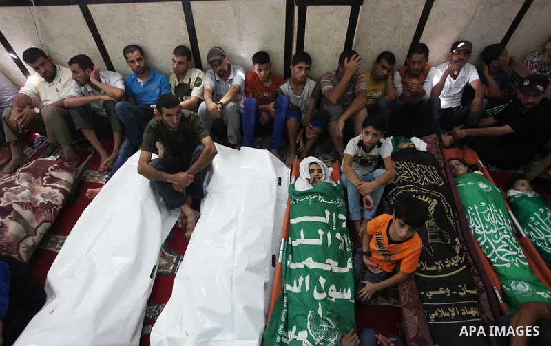 Palestinian relatives mourn for eight members of the Bayoumi family, who were killed in an Israeli air strike on their building, at Al Qassam mosque during their funeral in Nusseirat refugee camp, in the central Gaza Str...