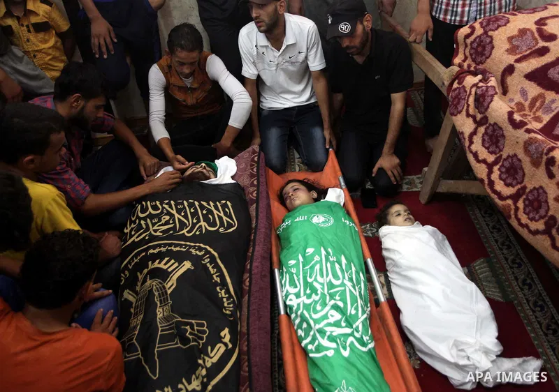 Palestinian relatives mourn for eight members of the Bayoumi family, who were killed in an Israeli air strike on their building, at Al Qassam mosque during their funeral in Nusseirat refugee camp, in the central Gaza Str...