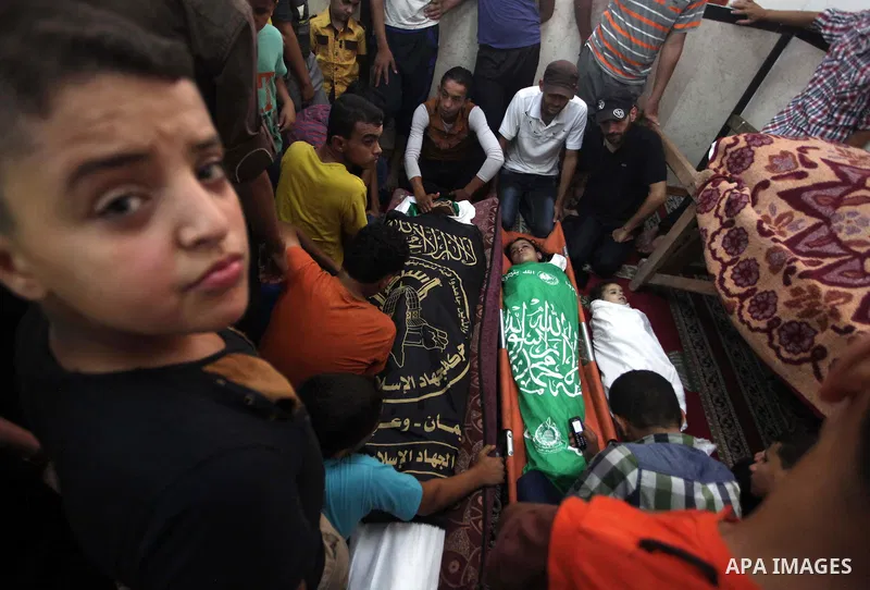 Palestinian relatives mourn for eight members of the Bayoumi family, who were killed in an Israeli air strike on their building, at Al Qassam mosque during their funeral in Nusseirat refugee camp, in the central Gaza Str...