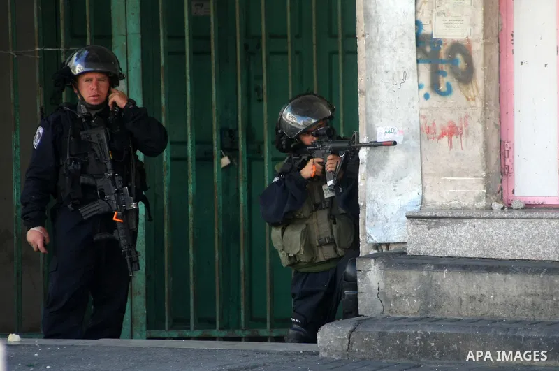 Israeli security forces stand guard on a street during clashes with Palestinian protesters on August 1, 2014 near the main entrance of the West bank city of Hebron following a protest against Israel's military operation...