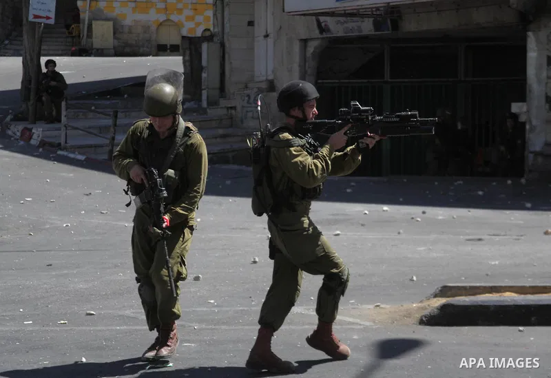 Israeli security forces stand guard on a street during clashes with Palestinian protesters on August 1, 2014 near the main entrance of the West bank city of Hebron following a protest against Israel's military operation...