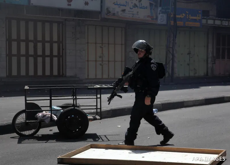 Israeli security forces stand guard on a street during clashes with Palestinian protesters on August 1, 2014 near the main entrance of the West bank city of Hebron following a protest against Israel's military operation...