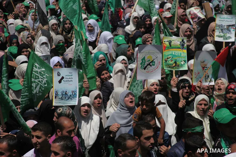 Palestinians hold placards during a demonstration against Israel's military operation in the Gaza Strip and in support of Gaza's people on August 1, 2014 in the West Bank town of Hebron. Some placards ask to refer Israel...