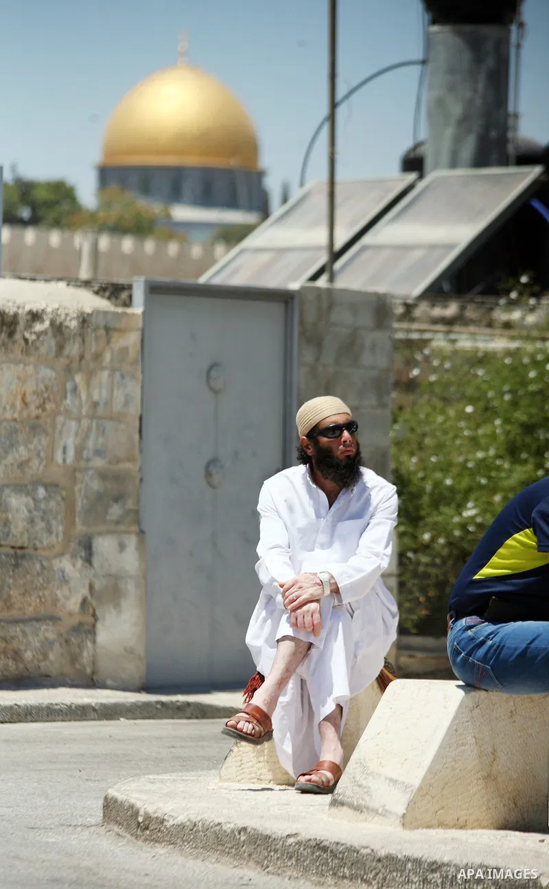 Palestinians pray as Israeli policemen guard during Friday prayers in the East Jerusalem neighbourhood of Wadi al-Joz August 1, 2014. Israeli police declared an age limit on Friday for Palestinians wanting to enter the O...
