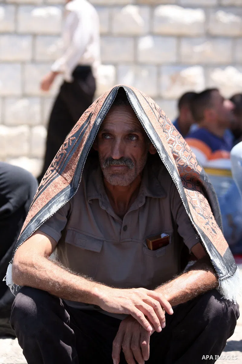 Palestinians pray as Israeli policemen guard during Friday prayers in the East Jerusalem neighbourhood of Wadi al-Joz August 1, 2014. Israeli police declared an age limit on Friday for Palestinians wanting to enter the O...