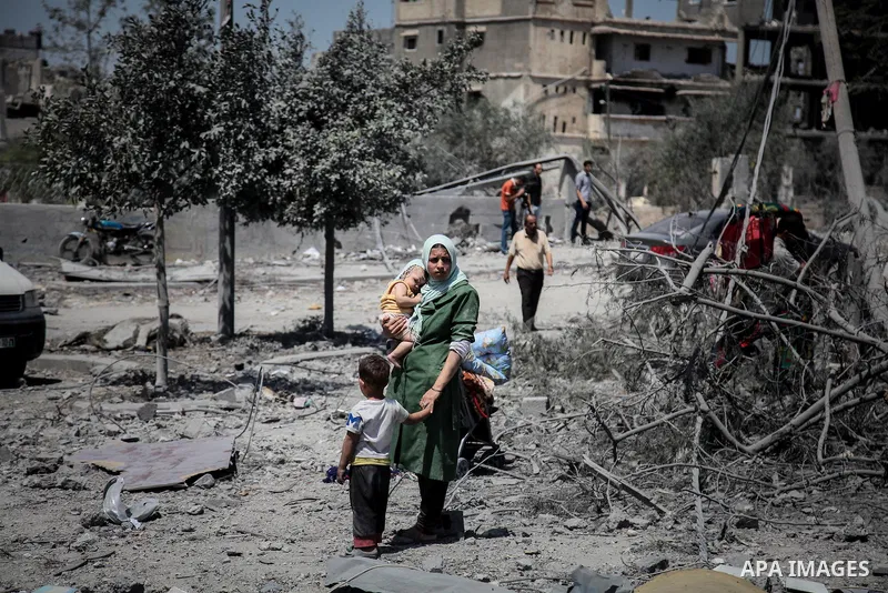 Palestinians carry their belongings after salvaging them from their destroyed house in the heavily bombed town of Beit Hanoun, Gaza Strip, close to the Israeli border, Friday, Aug. 1, 2014. A three-day Gaza cease-fire th...