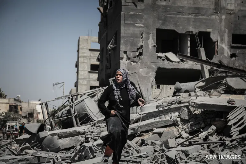 Palestinians carry their belongings after salvaging them from their destroyed house in the heavily bombed town of Beit Hanoun, Gaza Strip, close to the Israeli border, Friday, Aug. 1, 2014. A three-day Gaza cease-fire th...
