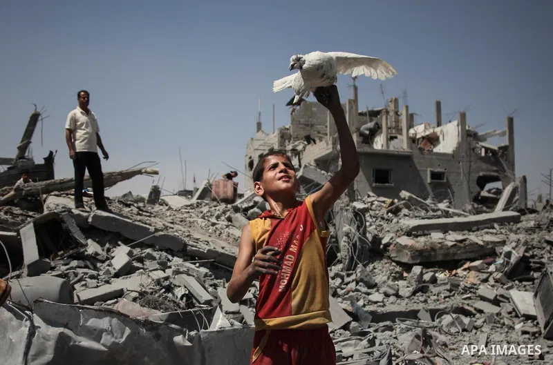Palestinians carry their belongings after salvaging them from their destroyed house in the heavily bombed town of Beit Hanoun, Gaza Strip, close to the Israeli border, Friday, Aug. 1, 2014. A three-day Gaza cease-fire th...