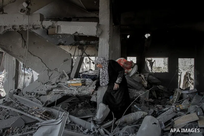 Palestinians carry their belongings after salvaging them from their destroyed house in the heavily bombed town of Beit Hanoun, Gaza Strip, close to the Israeli border, Friday, Aug. 1, 2014. A three-day Gaza cease-fire th...