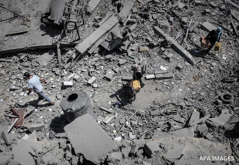 Palestinians carry their belongings after salvaging them from their destroyed house in the heavily bombed town of Beit Hanoun, Gaza Strip, close to the Israeli border, Friday, Aug. 1, 2014. A three-day Gaza cease-fire th...