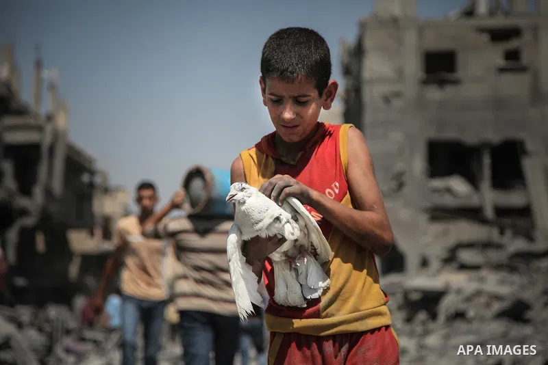 Palestinians carry their belongings after salvaging them from their destroyed house in the heavily bombed town of Beit Hanoun, Gaza Strip, close to the Israeli border, Friday, Aug. 1, 2014. A three-day Gaza cease-fire th...