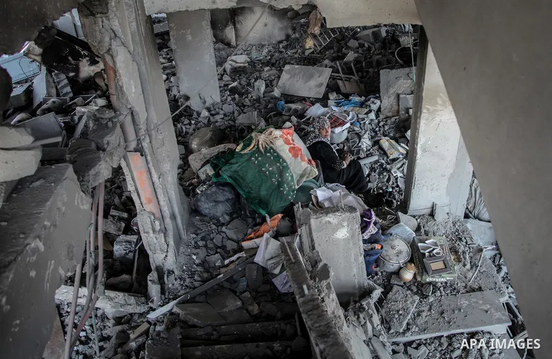 Palestinians carry their belongings after salvaging them from their destroyed house in the heavily bombed town of Beit Hanoun, Gaza Strip, close to the Israeli border, Friday, Aug. 1, 2014. A three-day Gaza cease-fire th...