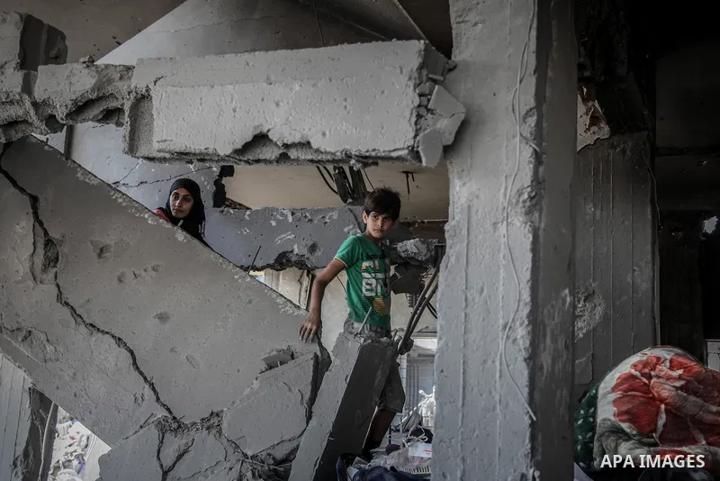 Palestinians carry their belongings after salvaging them from their destroyed house in the heavily bombed town of Beit Hanoun, Gaza Strip, close to the Israeli border, Friday, Aug. 1, 2014. A three-day Gaza cease-fire th...