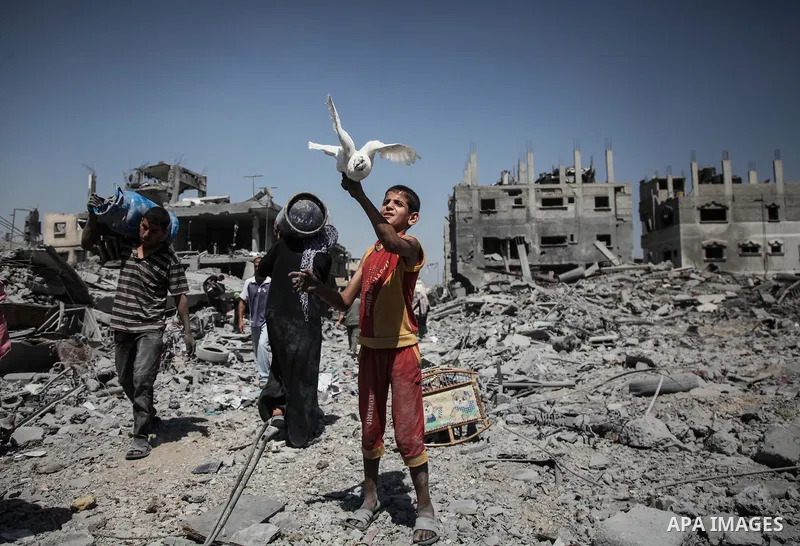 Palestinians carry their belongings after salvaging them from their destroyed house in the heavily bombed town of Beit Hanoun, Gaza Strip, close to the Israeli border, Friday, Aug. 1, 2014. A three-day Gaza cease-fire th...