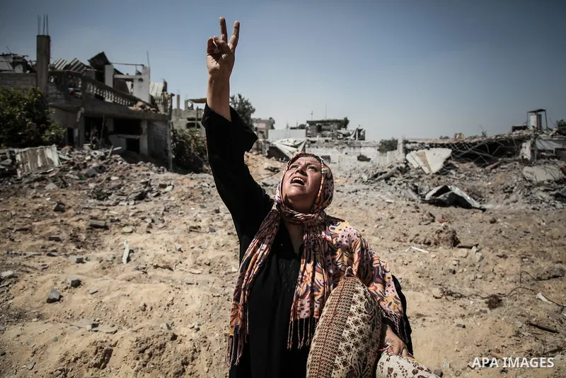 Palestinians carry their belongings after salvaging them from their destroyed house in the heavily bombed town of Beit Hanoun, Gaza Strip, close to the Israeli border, Friday, Aug. 1, 2014. A three-day Gaza cease-fire th...