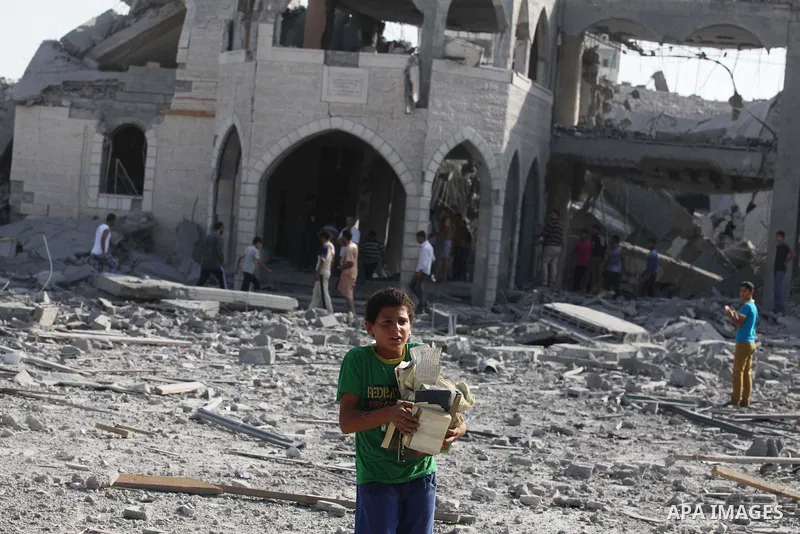 A Palestinian man carries pages of destroyed copies of the Koran, Islam's holy book, on August 2, 2014 after a mosque was hit in an overnight Israeli strike on Gaza City. A fresh wave of violence killed dozens in Gaza af...