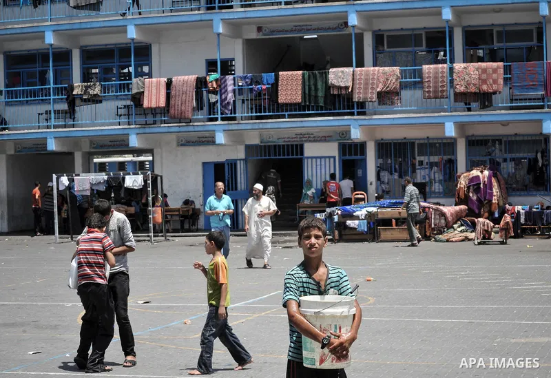 Displaced Palestinians gather at an United Nations (UN) school in Beit Lahia in the northern Gaza Strip, where they and his family found refuge after fleeing their home in an area under heavy Israeli bombardment in the b...