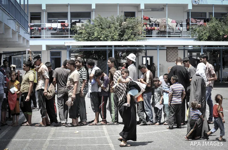 Displaced Palestinians gather at an United Nations (UN) school in Beit Lahia in the northern Gaza Strip, where they and his family found refuge after fleeing their home in an area under heavy Israeli bombardment in the b...