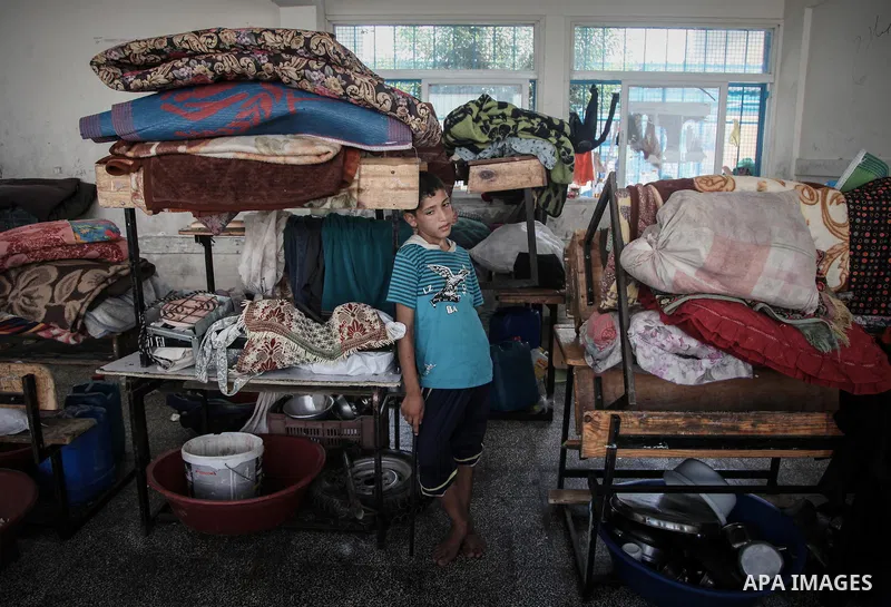 Displaced Palestinians gather at an United Nations (UN) school in Beit Lahia in the northern Gaza Strip, where they and his family found refuge after fleeing their home in an area under heavy Israeli bombardment in the b...