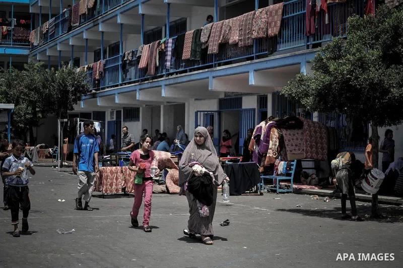 Displaced Palestinians gather at an United Nations (UN) school in Beit Lahia in the northern Gaza Strip, where they and his family found refuge after fleeing their home in an area under heavy Israeli bombardment in the b...