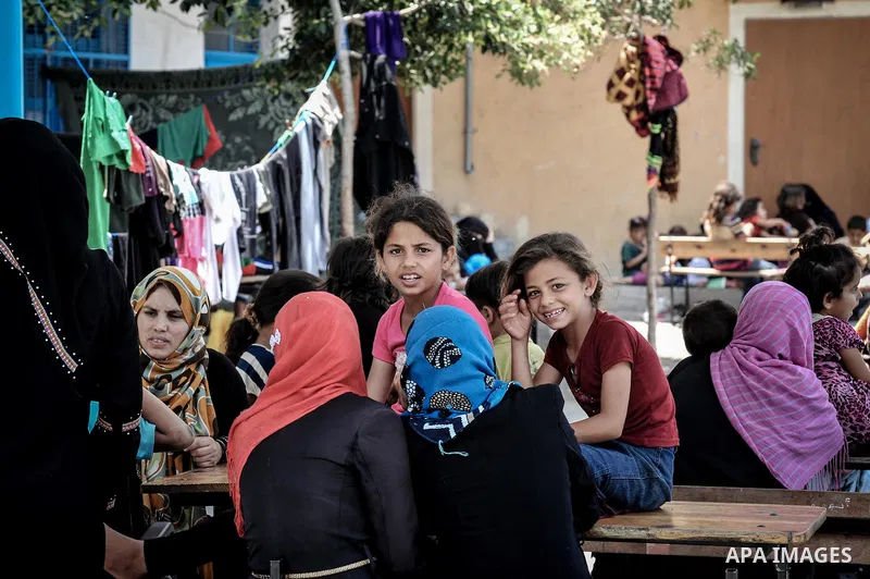 Displaced Palestinians gather at an United Nations (UN) school in Beit Lahia in the northern Gaza Strip, where they and his family found refuge after fleeing their home in an area under heavy Israeli bombardment in the b...